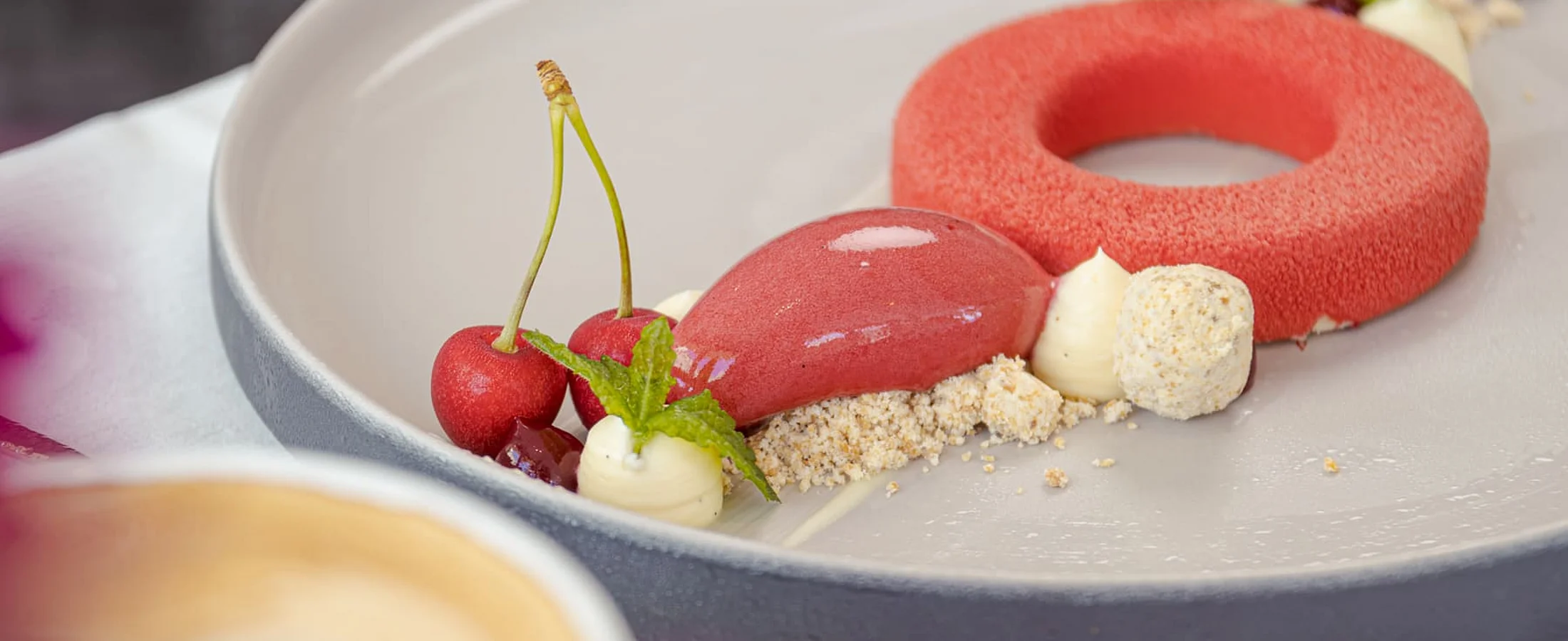 Exquisite fine dining dessert with cherry sorbet and mousse served on an elegant plate