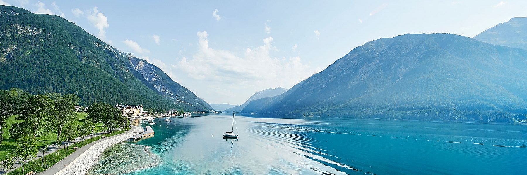 Kleines Segelboot auf dem kristallklaren Achensee im Sommer