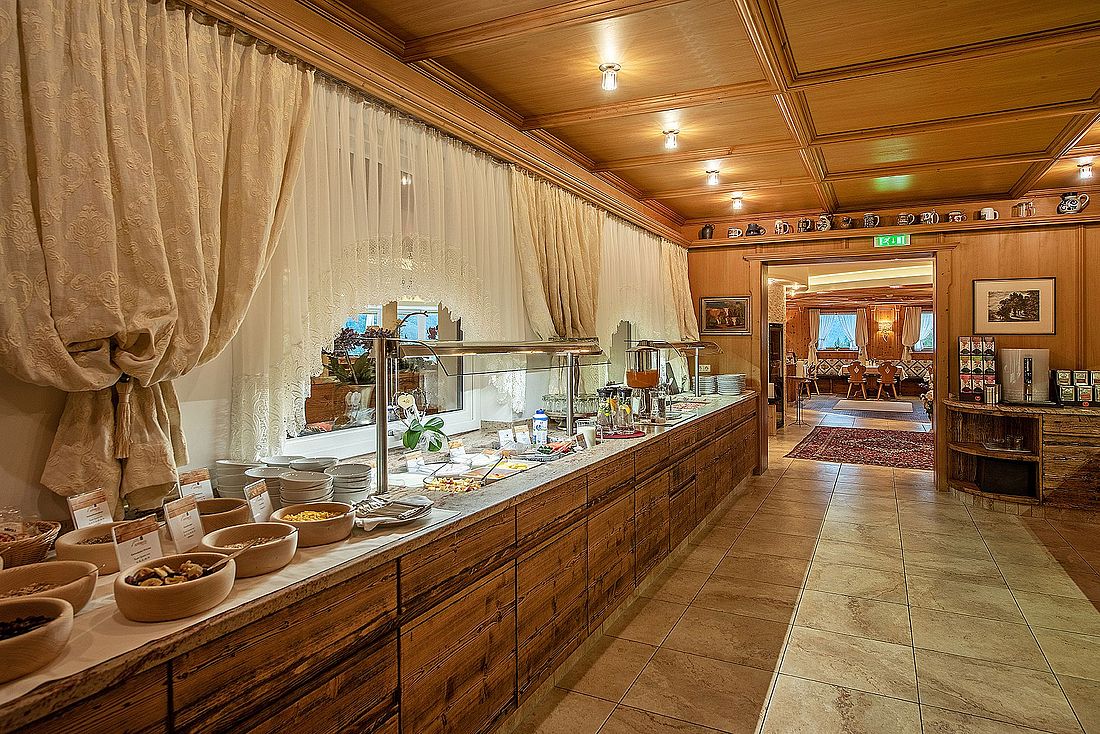 Gemütlicher Frühstücksraum mit Buffet, Holzdecke und liebevoller Dekoration im Tiroler Stil