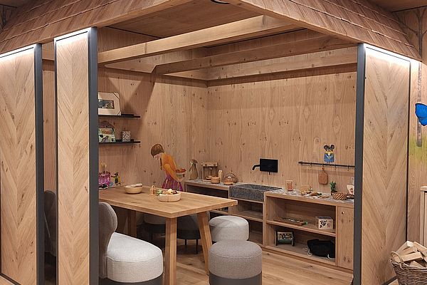 Kinderspielhaus aus Holz mit Sitzbereich, Spielküche und gemütlicher Einrichtung